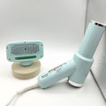 Light blue handheld device with a textured attachment on a white surface