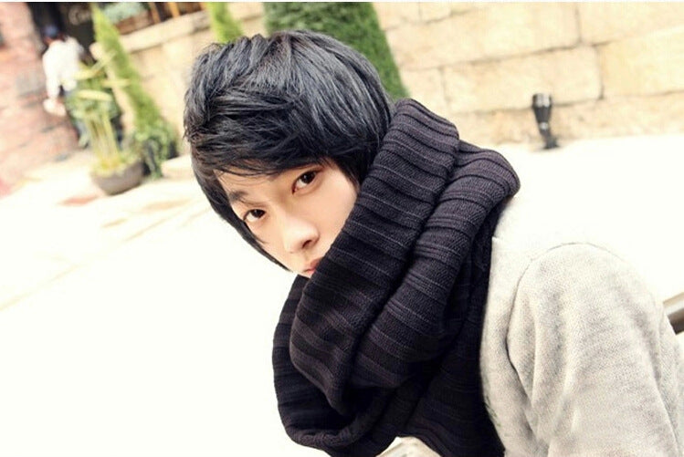 Person wearing a dark ribbed scarf outdoors
