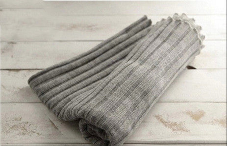 Folded gray blanket on a light wooden surface