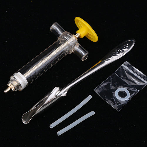 Medical syringe with yellow plunger, metal hook, and small plastic components on a black background